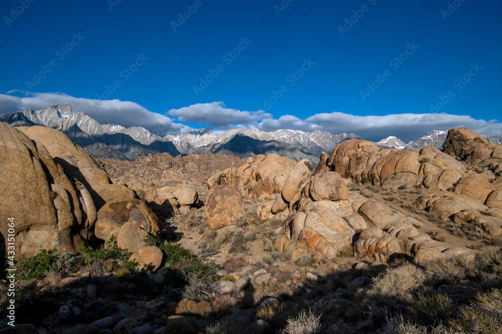 Skyline view of lenticular cloud, mountains, rocks and arch. Alabama Hills, California