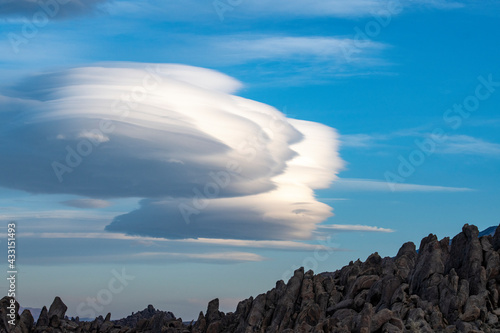 Skyline view of lenticular cloud, mountains, rocks. Alabama Hills, California