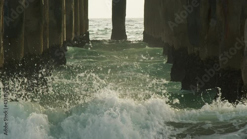 Wallpaper Mural Super slow motion of water splashes breaking off the pier pillars. Ocean droplets highlighted in sunset summer light. Seascape background. Shot on RED helium weapon cinema camera. Torontodigital.ca