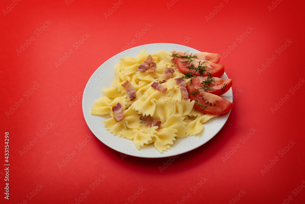 pasta bacon and tomatoes on a whote plate dinner