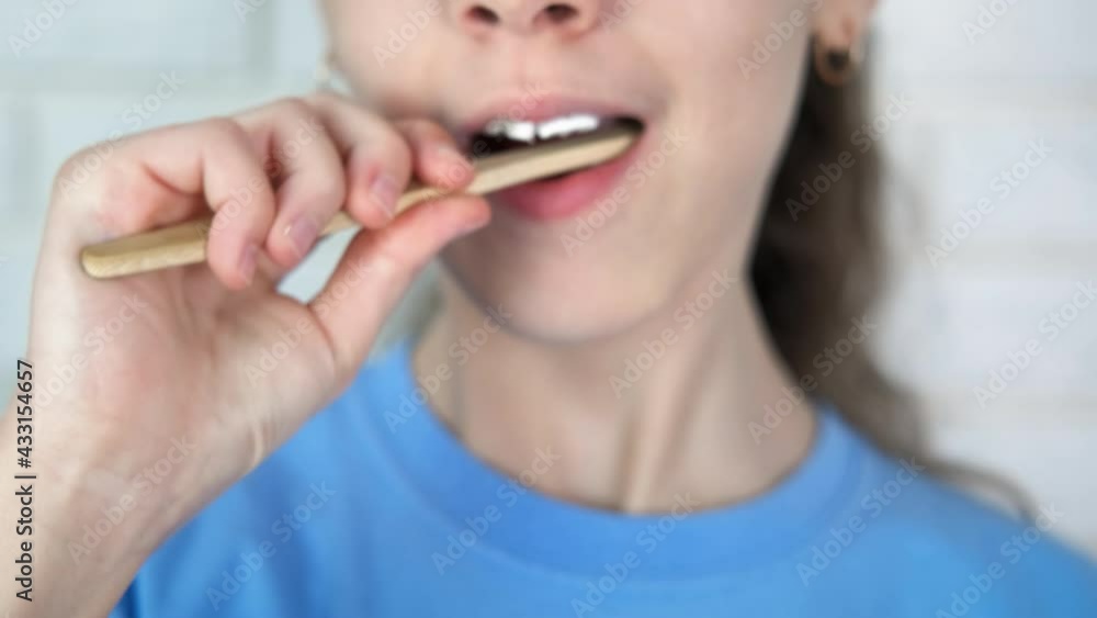 Morning child hygiene. A child brush her teeth with an organic teethbrush and a white good paste in the morning. Morning child hygiene. A child brush her teeth with an organic teethbrush and a white good paste in the morning.