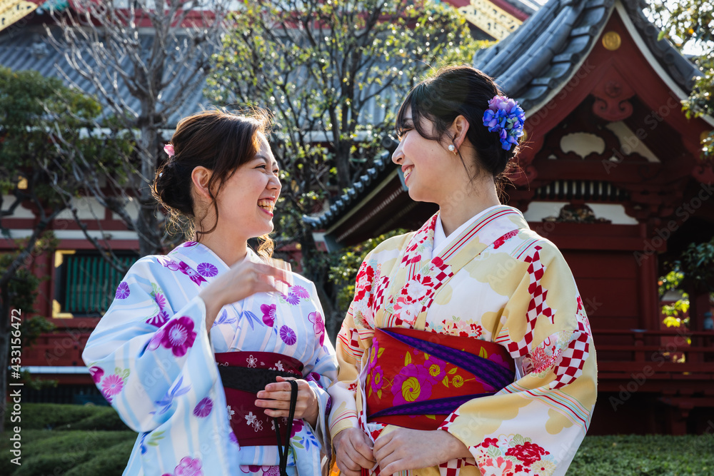 Two young women in kimono talking outdoors, Tokyo Two young women in kimono talking outdoors, Tokyo