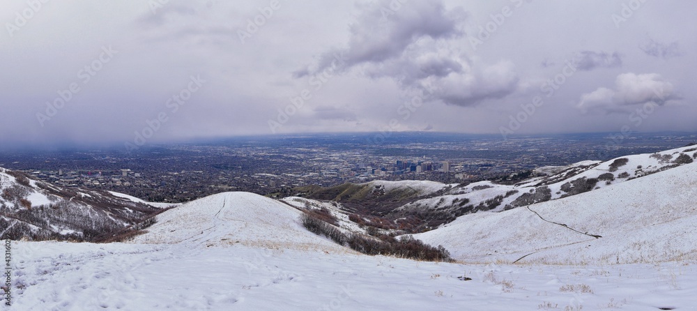Obraz premium Downtown Salt Lake City View from Little Black Mountain Peak winter snowscape mountain hiking trail views via Bonneville Shoreline Trail, Wasatch Front Rocky Mountains, Utah. United States.