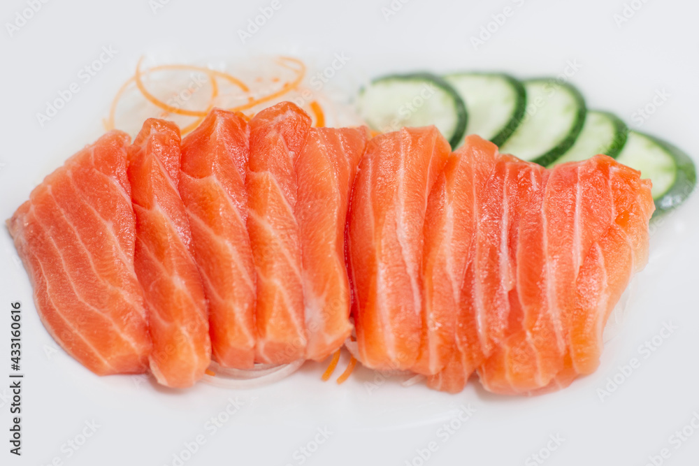 raw salmon red fish with vegetables on white plate raw salmon red fish with vegetables on white plate