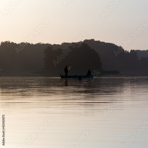Krajobraz konturówka pejzaż łódka zarysy sylwetek dwóch wędkarzy łowiących ryby na jeziorze