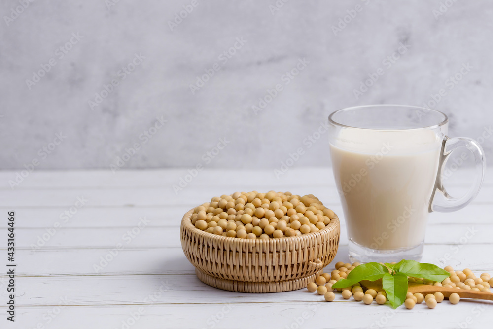 Soy and soy milk in a glass with soybeans in wooden bowl background Soy and soy milk in a glass with soybeans in wooden bowl background