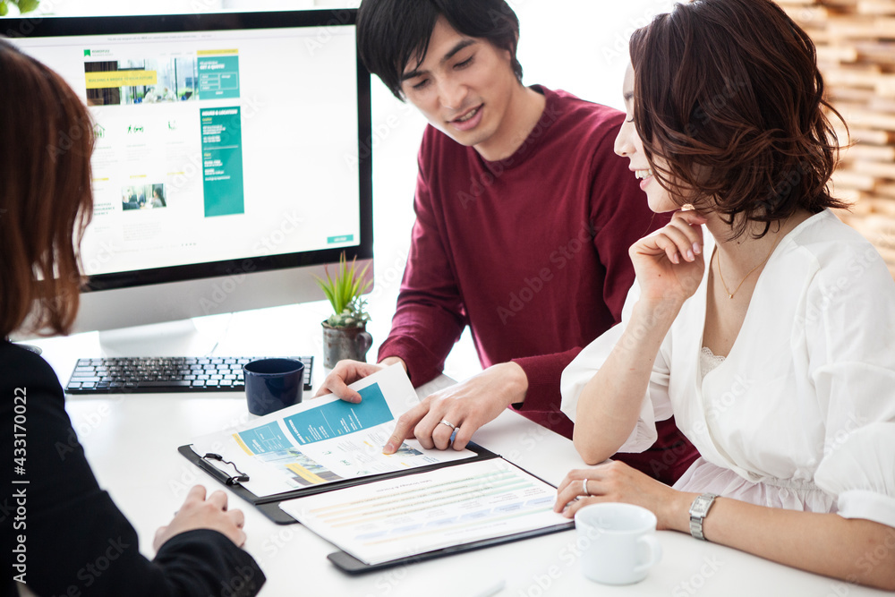 Fototapeta premium 保険の営業資料を見ながら確認をする夫婦