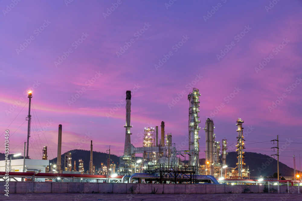 Oil refinery industry power station plant under working production petrochemical energy at dark night sky background.