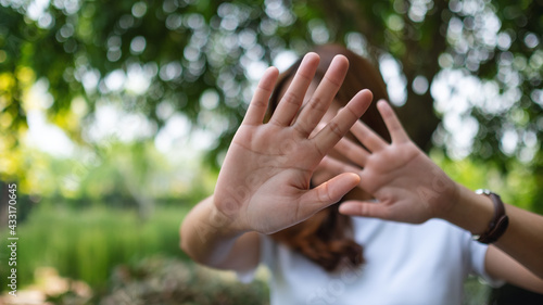 A woman outstretched hand and showing stop hand sign