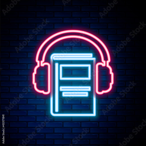 Glowing neon line Audio book icon isolated on brick wall background. Book with headphones. Audio guide sign. Online learning concept. Colorful outline concept. Vector