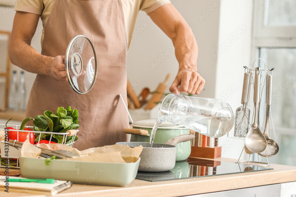 Fototapeta premium Young man cooking in kitchen