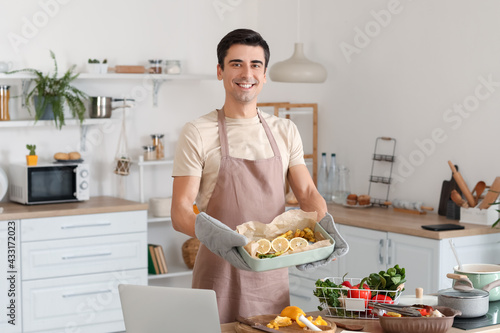 Young man with baking dish ...