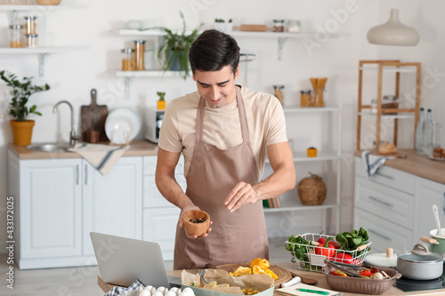 Young man cooking in kitchen