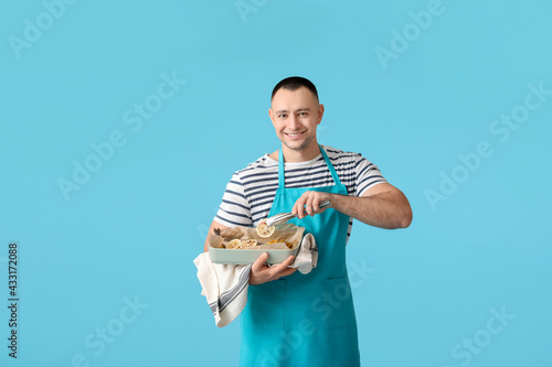 Young man with baking dish ...