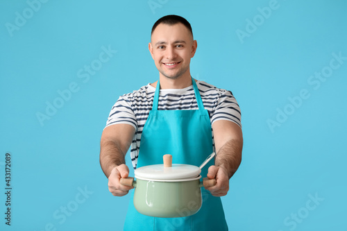 Young man with cooking pot ...