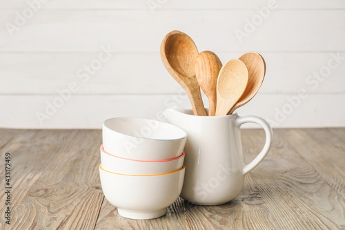 Spoons and bowls on light wooden background
