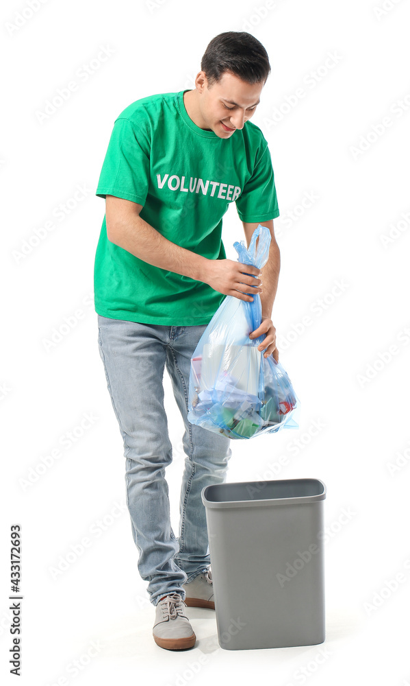 Male volunteer putting garbage in trash bin on white background Male volunteer putting garbage in trash bin on white background