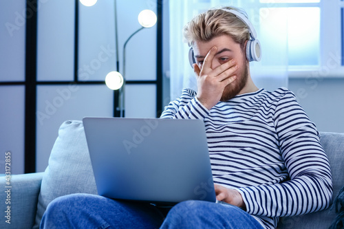 Young man with laptop playi...