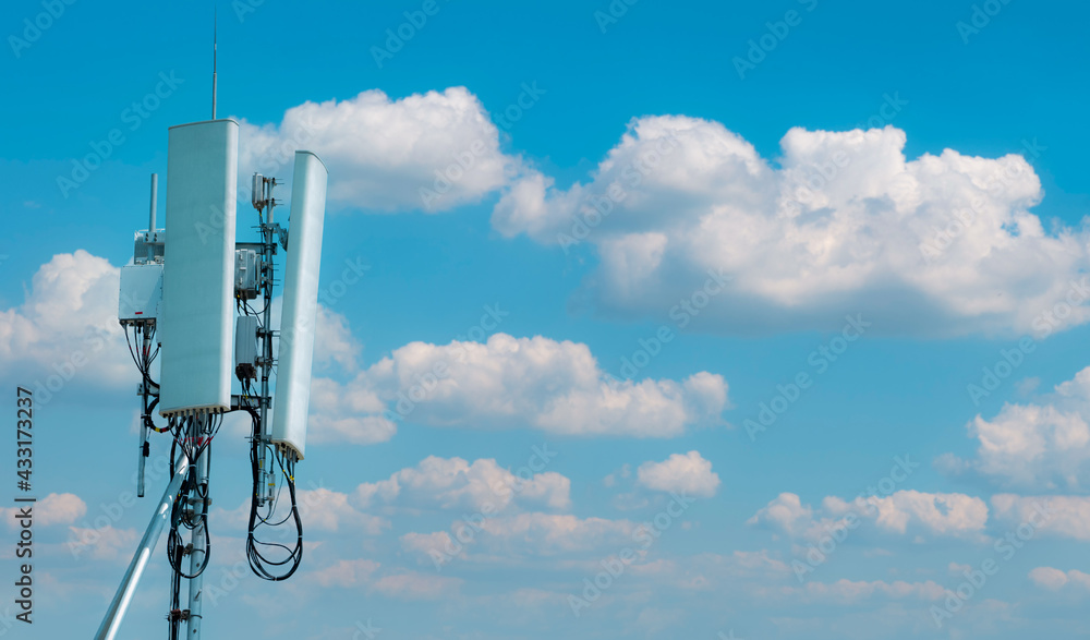 Telecommunication tower with blue sky and white clouds background. Antenna on blue sky. Radio and satellite pole. Communication technology. Telecommunication industry. Mobile or telecom 4g network. Telecommunication tower with blue sky and white clouds background. Antenna on blue sky. Radio and satellite pole. Communication technology. Telecommunication industry. Mobile or telecom 4g network.
