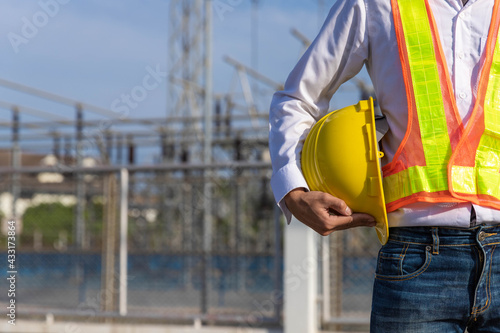 A young engineer standing with a yellow hat in his hand at the main power station.