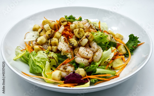 Fresh shrimp salad with lettuce on white dish.