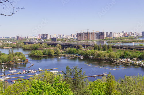 City landscape. Bridge over river. Yacht moorage on the river bank.