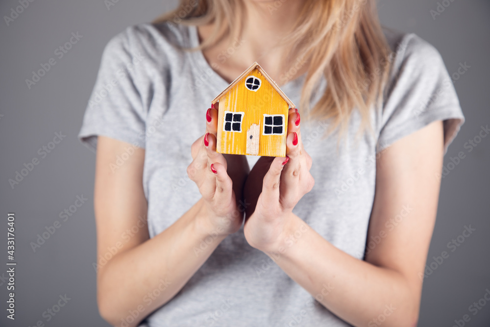 woman holding wooden house model woman holding wooden house model