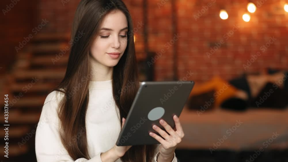 A woman is sitting in her home office. She is working on a tablet. Portrait shooting. 4K A woman is sitting in her home office. She is working on a tablet. Portrait shooting. 4K