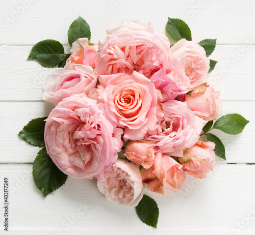 Pink roses on white wooden board.Template for greeting card