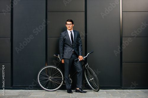 Handsome young business man with his modern bicycle. © oneinchpunch