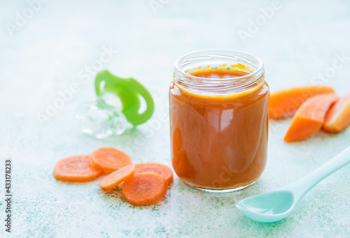 Baby carrot mashed with spoon in glass jar