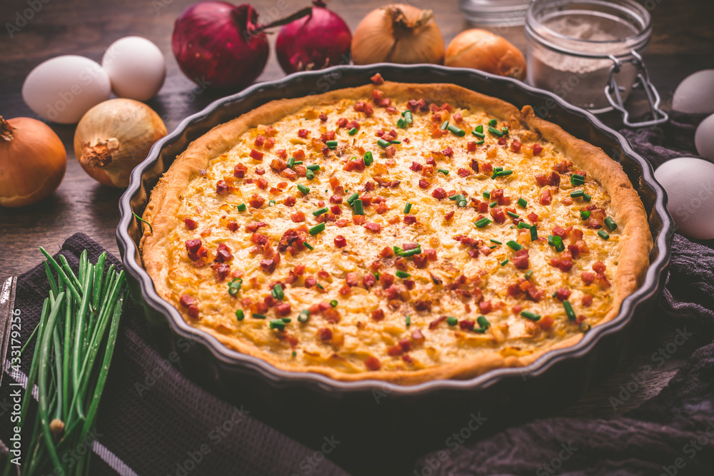 Homemade onion tart or pie with bacon and chives