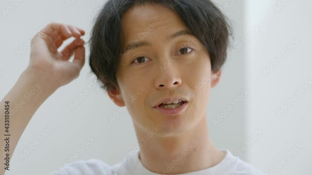 笑顔で髪を触る男性 笑顔で髪を触る男性