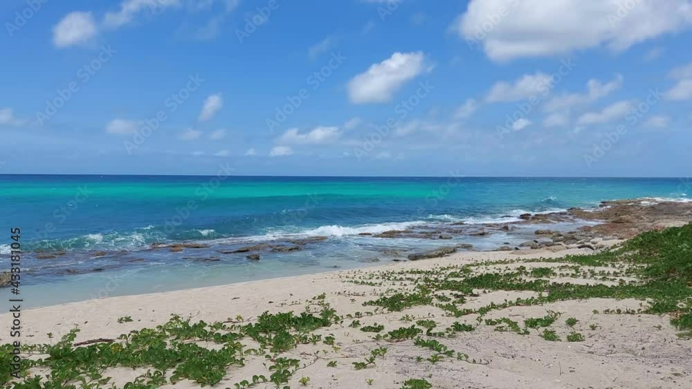 wave cursing to a rocky beach blue sky and sea in Philipsburg St. Maarten wave cursing to a rocky beach blue sky and sea in Philipsburg St. Maarten