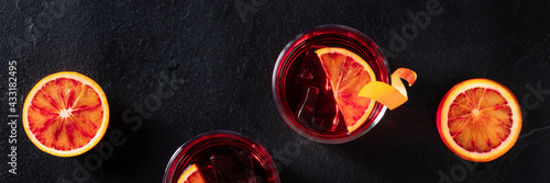 Orange cocktails panorama on a black background. Campari with blood oranges photo