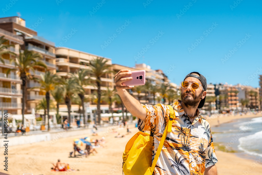 A young tourist with the phone on Playa del Cura in the coastal city of Torrevieja, Alicante, Valencian Community. Spain, Mediterranean Sea