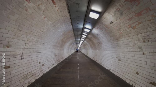 The view of the empty Greenwich foot tunnel in east with a cyclist going through photo