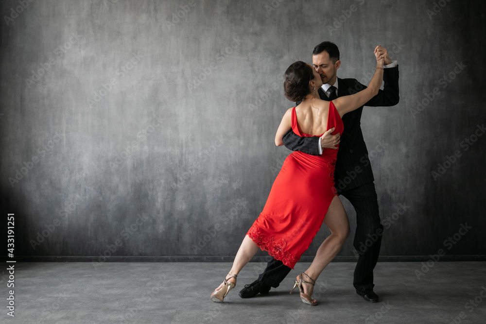Couple Of Professional Tango Dancers In Elegant Suit And Dress Pose In A Dancing Movement On