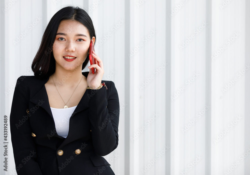 Portrait of Businesswoman standing in black suit. Asian woman holding hand smartphone in white background. Concept beautifull lady working confident. Portrait of Businesswoman standing in black suit. Asian woman holding hand smartphone in white background. Concept beautifull lady working confident.