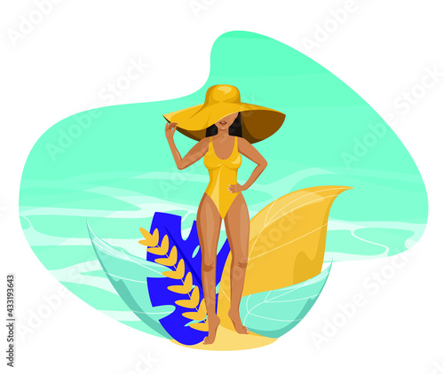 A beautiful young woman in a hat and a swimsuit on the background of the blue sea. Relax on the beach. A tanned girl.