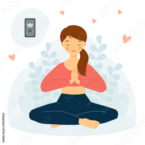 The girl practices yoga with phone. Meditation concept. Yoga Mobile App. Girl in lotus pose. Namaste.