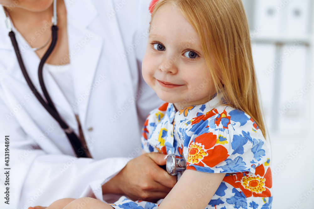 Happy smiling girl at usual medical inspection. Doctor and patient in clinic. Medicine, healthcare concepts Happy smiling girl at usual medical inspection. Doctor and patient in clinic. Medicine, healthcare concepts
