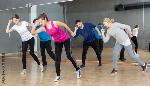 Fototapeta Naklejka Na Ścianę i Meble -  Group of adult people training in gym, doing aerobics exercises