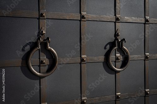Obraz na plátně Forged decorative door handles in the shape of a ring on a metal gate