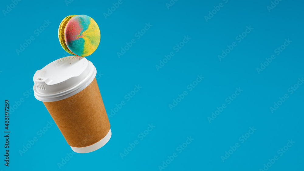 Traditional french macaron and coffee paper cup flying on blue background Macaron or macaroon hang in the air Сookies Copy space Cafe concept Cafe menu desing Traditional french macaron and coffee paper cup flying on blue background Macaron or macaroon hang in the air Сookies Copy space Cafe concept Cafe menu desing