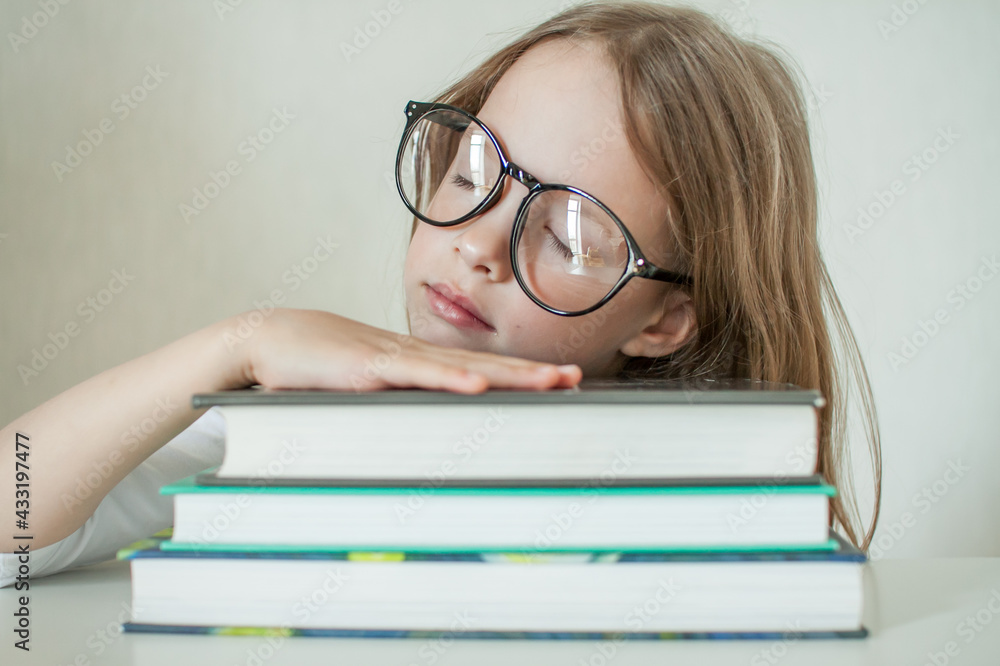 Little girl with glasses does homework, reads books. High quality photo Little girl with glasses does homework, reads books. High quality photo