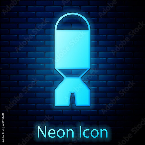 Glowing neon Rocket launcher with missile icon isolated on brick wall background. Vector
