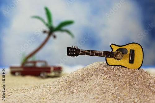 Guitar on Tropical Beach with Vintage Hot Rod in Background photo