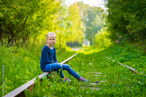 girl sitting on an old railroad, summer, outdoor walks happy childhood selective focus