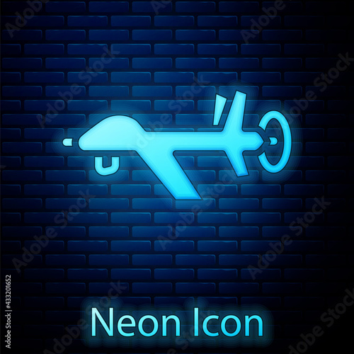 Glowing neon UAV Drone icon isolated on brick wall background. Military Unmanned aircraft spy. Vector